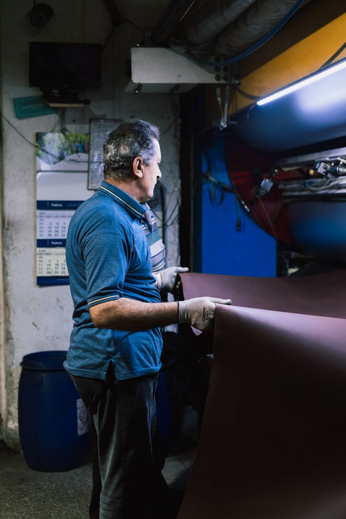 A leather artisan in Gerede, Türkiye, skillfully handles leather sheets inside a traditional tannery.